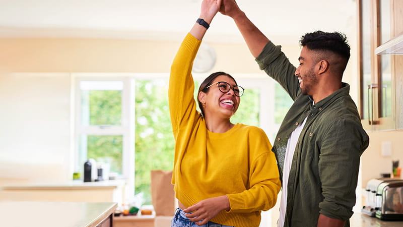 Una pareja joven baila en su cocina