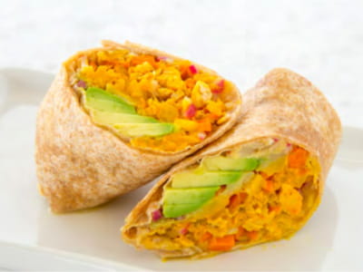 A tuna wrap with avocado is sliced in half and arranged on a plate.
