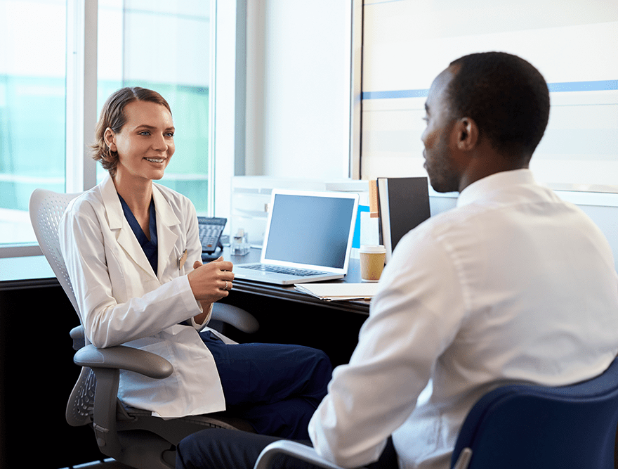Médico en consulta con un paciente de sexo masculino Médico en consulta con un paciente de sexo masculino