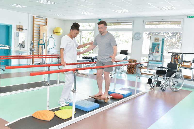 man working with physical therapist